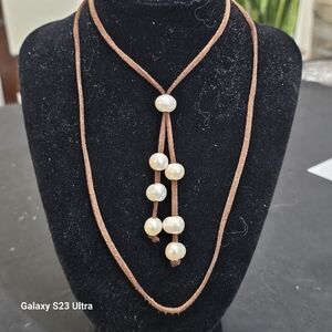 Set of necklace, bracelet, earrings,  and ring in leather cord and pearls.